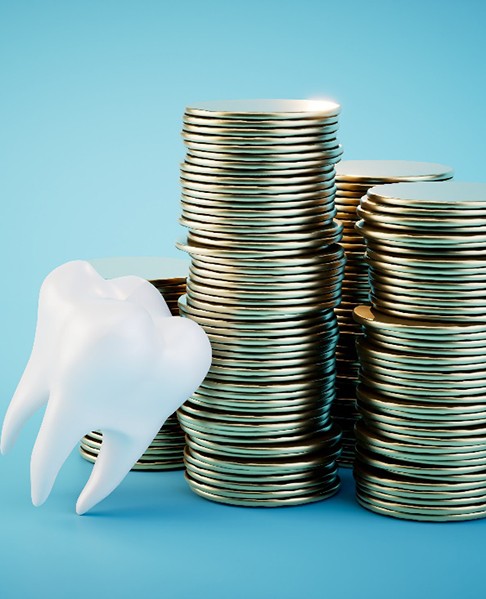 a model of a tooth near stacks of coins
