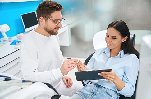 Dentist handing a clipboard to a patient