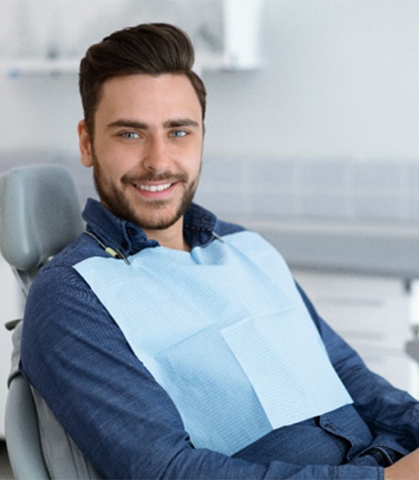Man sitting in the dental chair smiling before guided dental implant surgery in Dallas