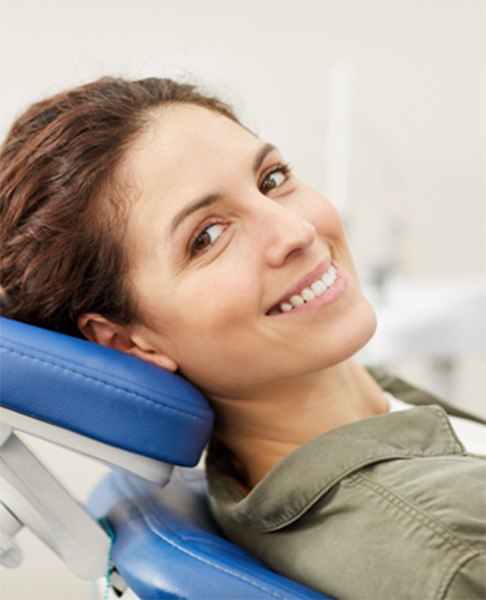 Woman leaning back in the dental chair and smiling