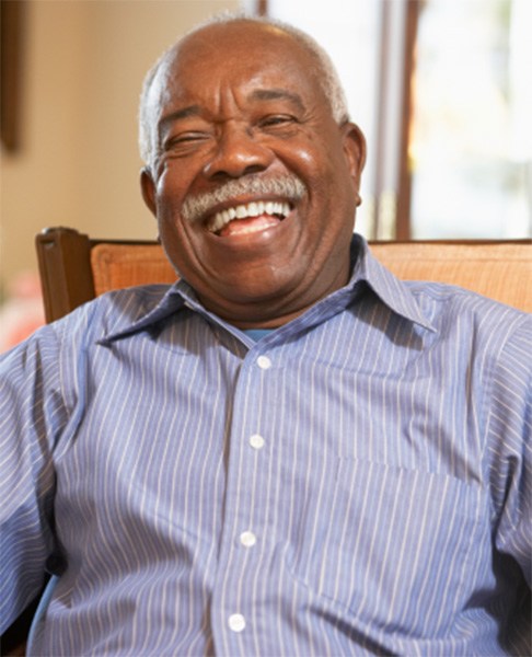 Senior man sitting in the dental chair and laughing