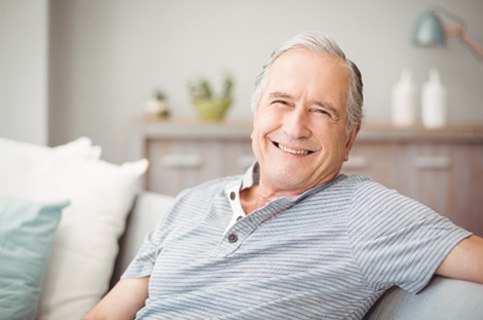 Older man sitting on a couch and smiling