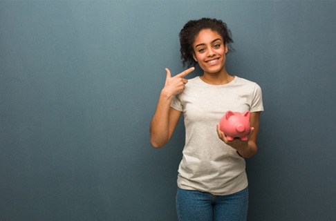 Someone holding a piggy bank and pointing at their smile