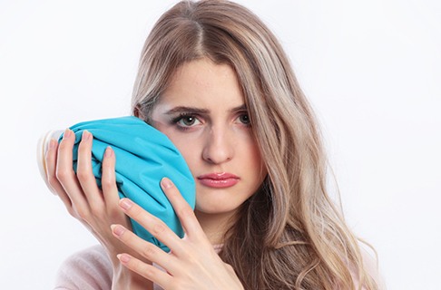 Woman holding an ice pack to her cheek