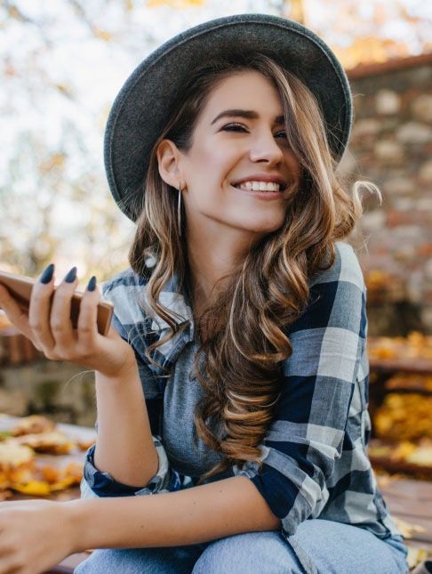 Woman in a plaid shirt smiling outdoors