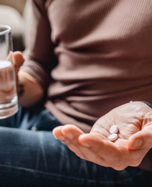 Holding glass of water and pills