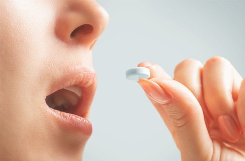 Holding glass of water and pills
