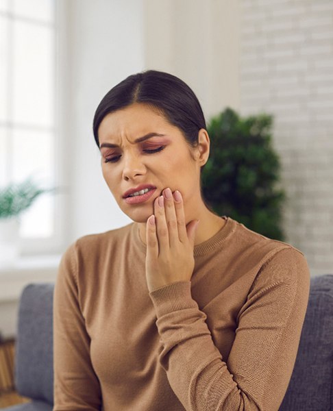 Woman holding the side of her cheek in pain