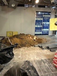 Trash bags, pile of dirt, and steel beams