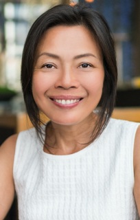 Woman in a sleeveless white blouse smiling