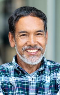 Man in a blue plaid shirt smiling