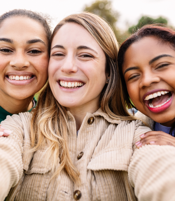 Three women smiling outdoors