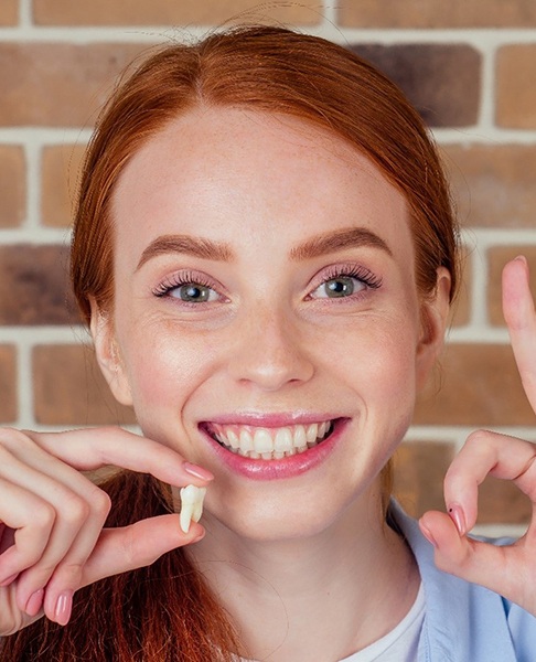 Woman making an okay sign with her hand after wisdom tooth extractions